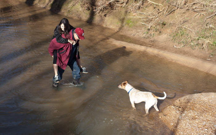 Dad carries Ana across the creek